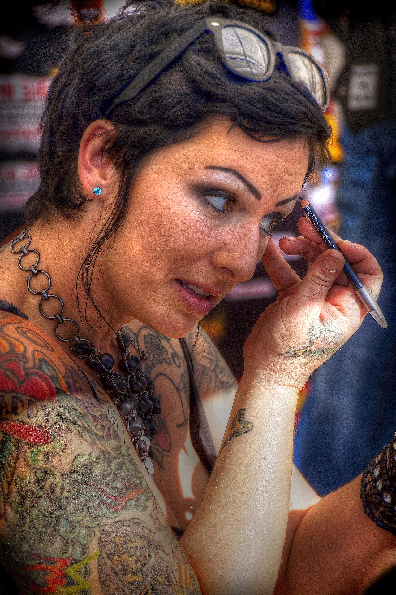 A woman using a pencil to define her eyebrow